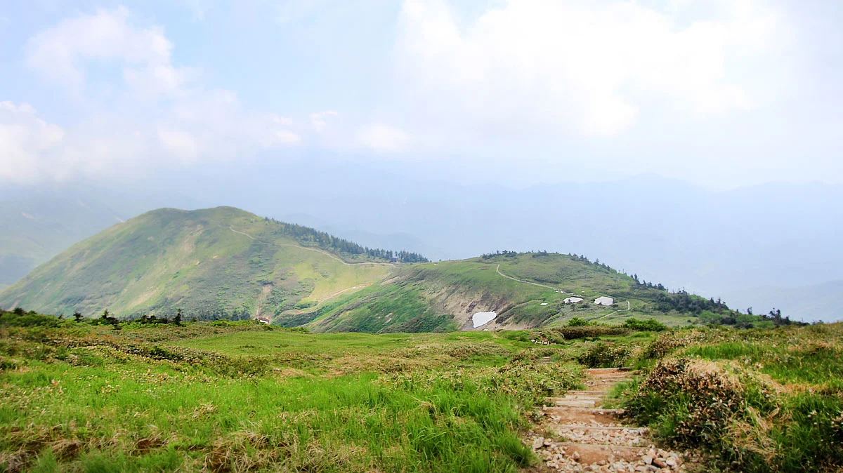 正面奥に避難小屋、左奥に前巻機山