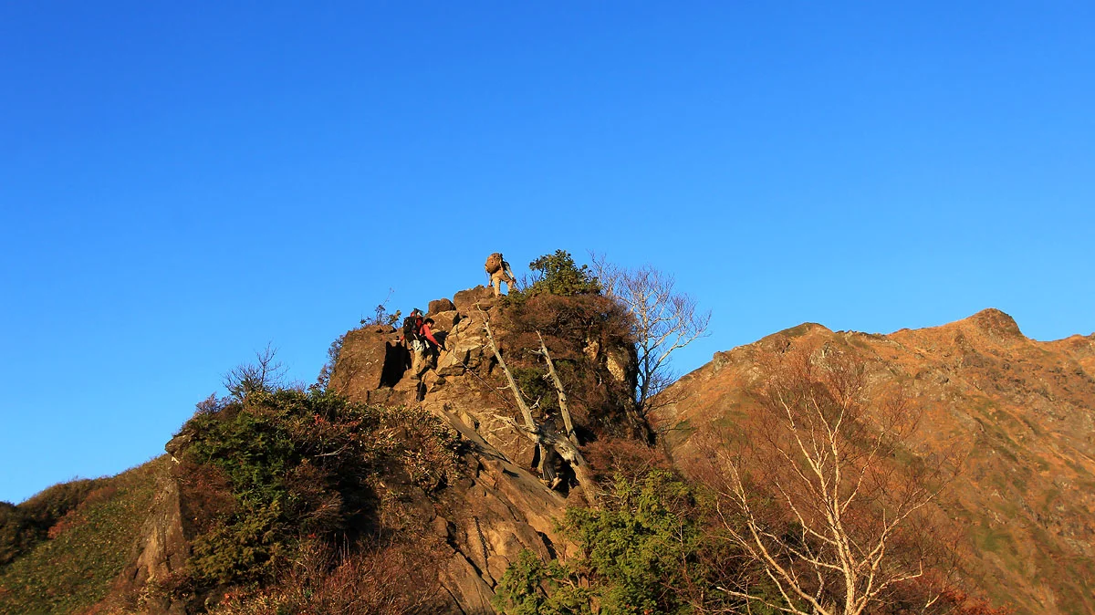 岩をよじ登る登山者